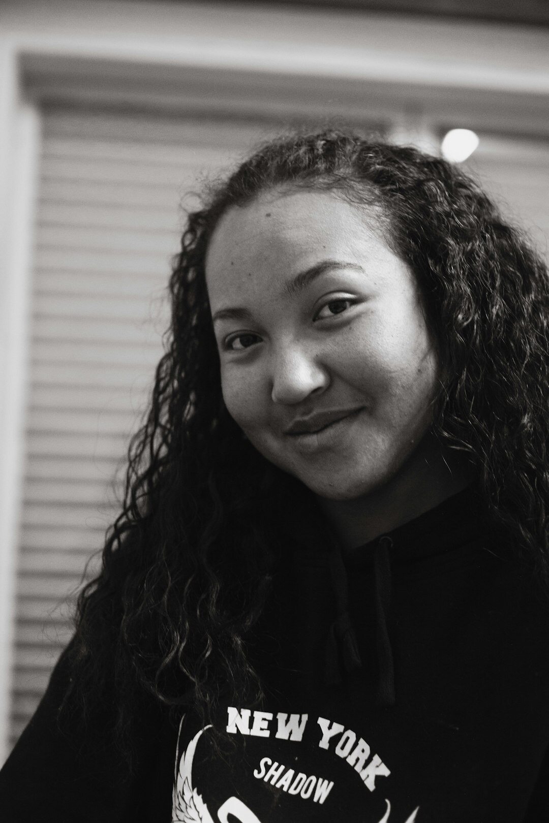 Studio portrait of a woman with curly hair smiling